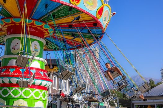 Kermis regio op een marktplein met botsauto's, lichtjes en bezoekers in de avond