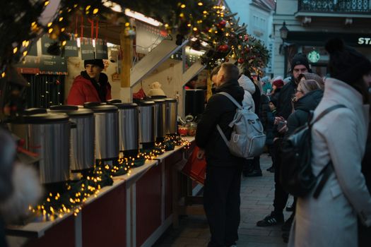 Bezoekers op een sfeervolle kerstmarkt regio met verlichte kraampjes en kerstboom op het marktplein