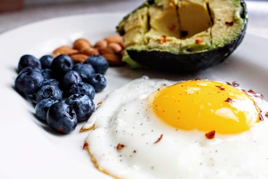 Gezonde keto maaltijd met zalm, avocado, broccoli en eieren op een keukentafel thuis
