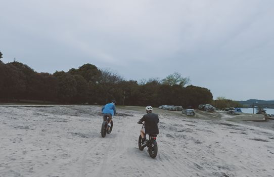 Ouder praat met kind naast een mini fatbike met helm in een woonwijk