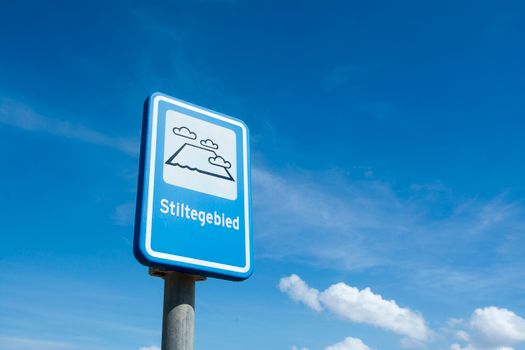 Weerbericht voor Regio met donkere wolken, nat wegdek en druk verkeer bij een kruispunt in de spits